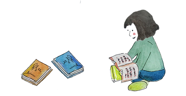 Ein Kind sitzt mit einem aufgeschlagenen Buch im Schneidersitz